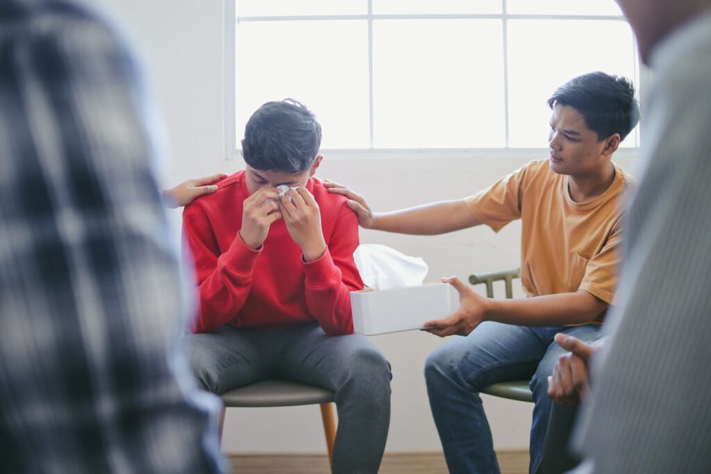 Man receiving emotional support during addiction recovery at a sober living home in Columbus, Ohio, surrounded by peers encouraging lasting sobriety.